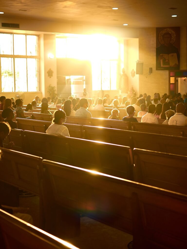 pexels photo 12618113 12618113 Sunlit church interior filled with people during a service, highlighting a serene religious atmosphere.
