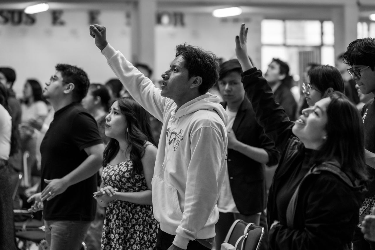 Black and white photo of people worshiping in Ciudad de México, Mexico.